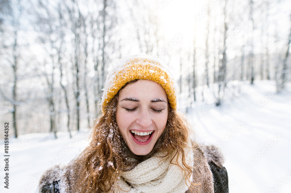 Portrait of young woman in the snowy nature, snow stuck to her clothes, face and hair. First snowfall of the season. Portrait of young woman in the snowy nature, snow stuck to her clothes, face and hair. First snowfall of the season.