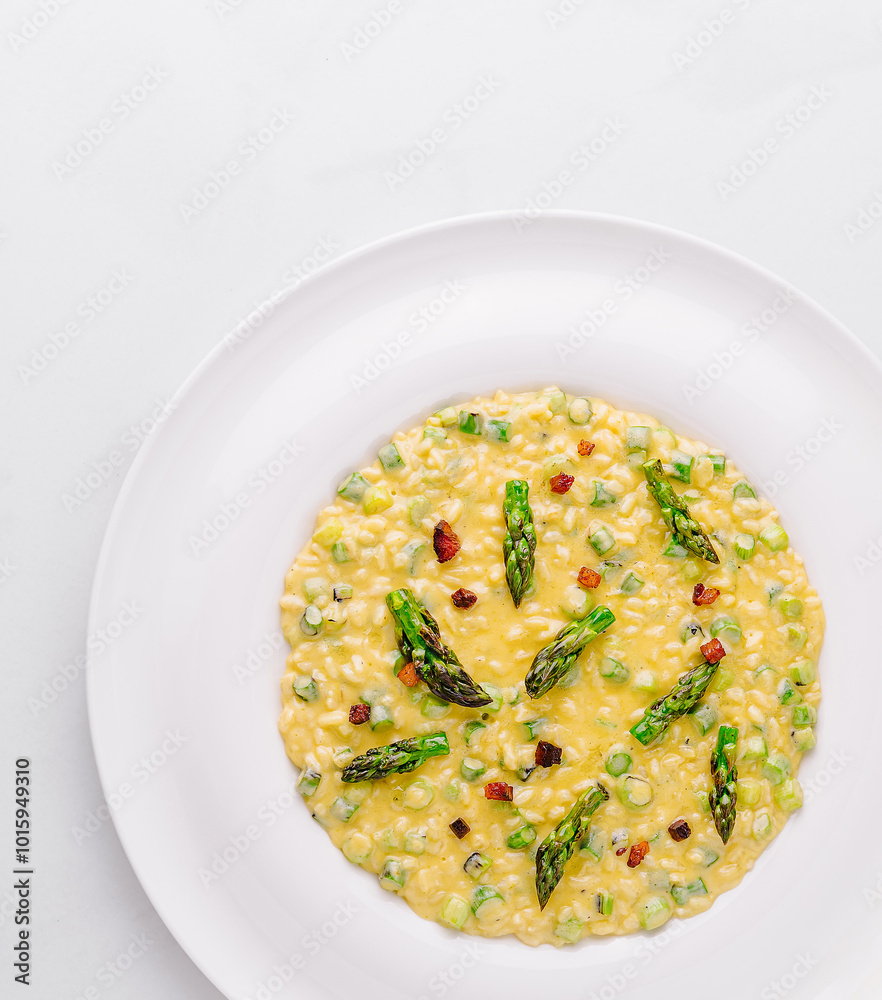 Creamy risotto being served with asparagus and pancetta Creamy risotto being served with asparagus and pancetta