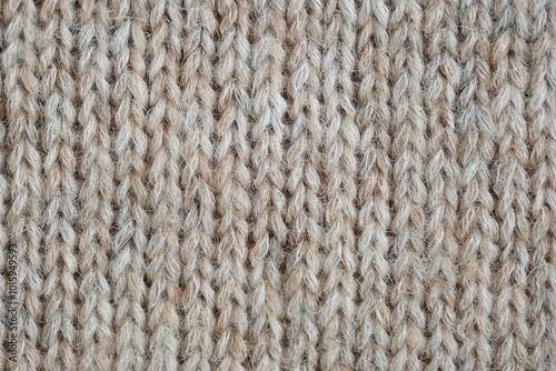 The texture of fabric thick beige sweater close-up. Knitted texture background