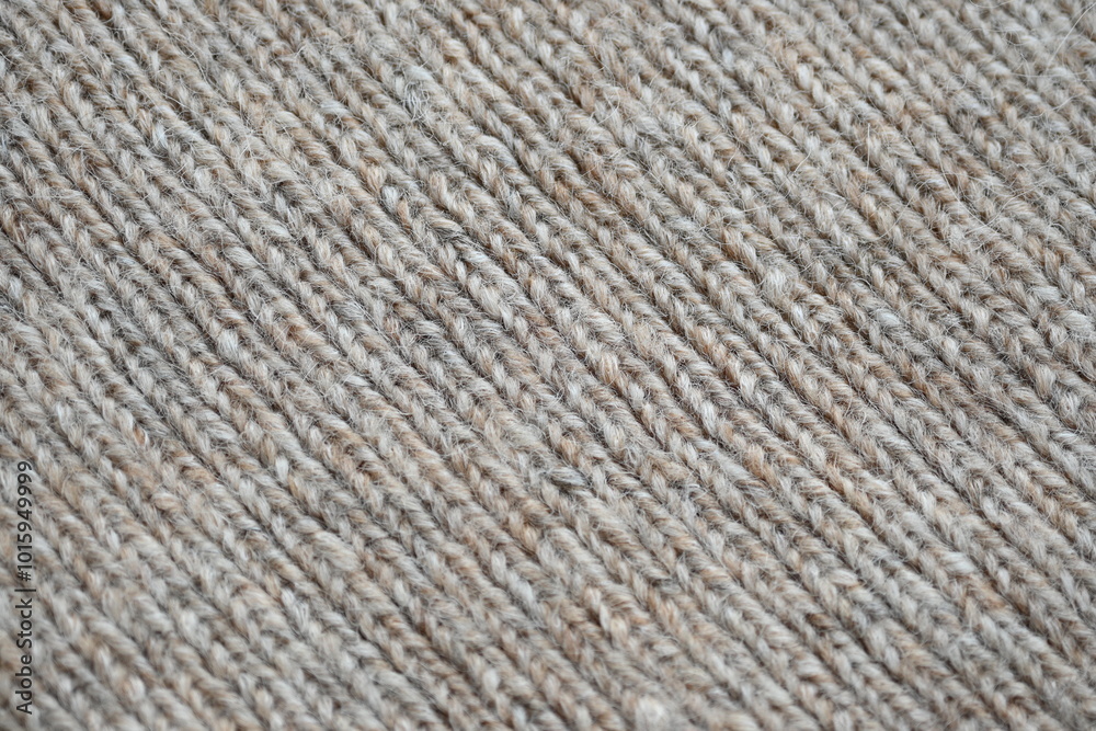 The texture of fabric thick beige sweater close-up. Knitted texture background The texture of fabric thick beige sweater close-up. Knitted texture background