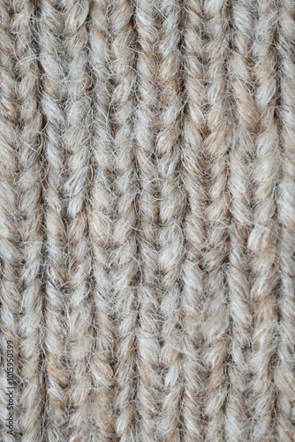 The texture of fabric thick beige sweater close-up. Knitted texture background