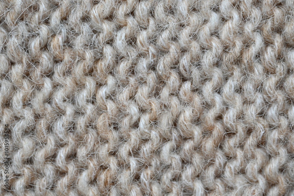 The texture of fabric thick beige sweater close-up. Knitted texture background The texture of fabric thick beige sweater close-up. Knitted texture background