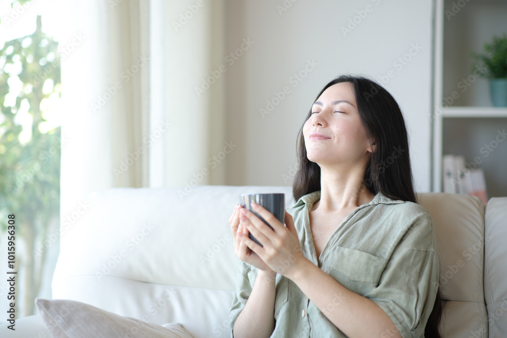 Asian woman breathing drinking coffee at home Asian woman breathing drinking coffee at home