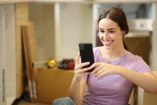 Happy woman moving home using cell phone