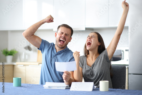 Excited couple celebrating holding receipt