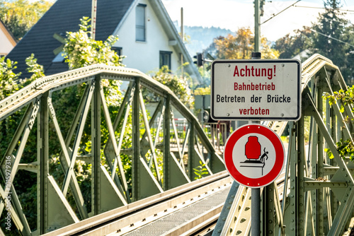 German sign on a train bridge warning people from falling of the bridge photo