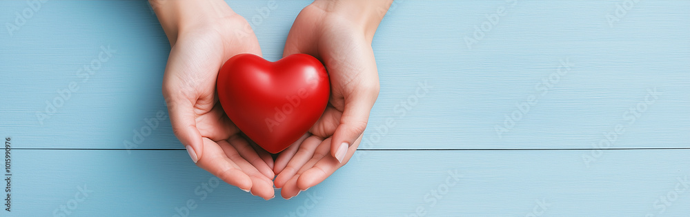 Love and Care in Hands: Conceptual Image of Holding a Red Heart on Light Blue Background with Copy Space for Web Banner Design Love and Care in Hands: Conceptual Image of Holding a Red Heart on Light Blue Background with Copy Space for Web Banner Design