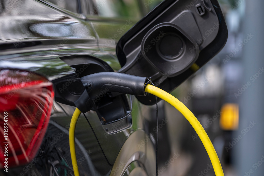 Close examination of an electric vehicle charging station, focusing on the connector, representing the shift towards sustainable energy and modern technology advancement. Close examination of an electric vehicle charging station, focusing on the connector, representing the shift towards sustainable energy and modern technology advancement.