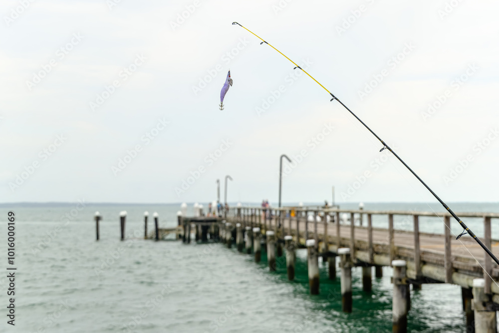 Fishing rods and reels on Kingfisher Bay jetty, K'gari Fraser Island, catching fish leisure recreation, ocean coastal beach lifestyle, retirement hobby Fishing rods and reels on Kingfisher Bay jetty, K'gari Fraser Island, catching fish leisure recreation, ocean coastal beach lifestyle, retirement hobby
