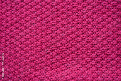 pink texture of knitted wool fabric as a background, smooth symmetrical lines of hand-knitted needlework pattern