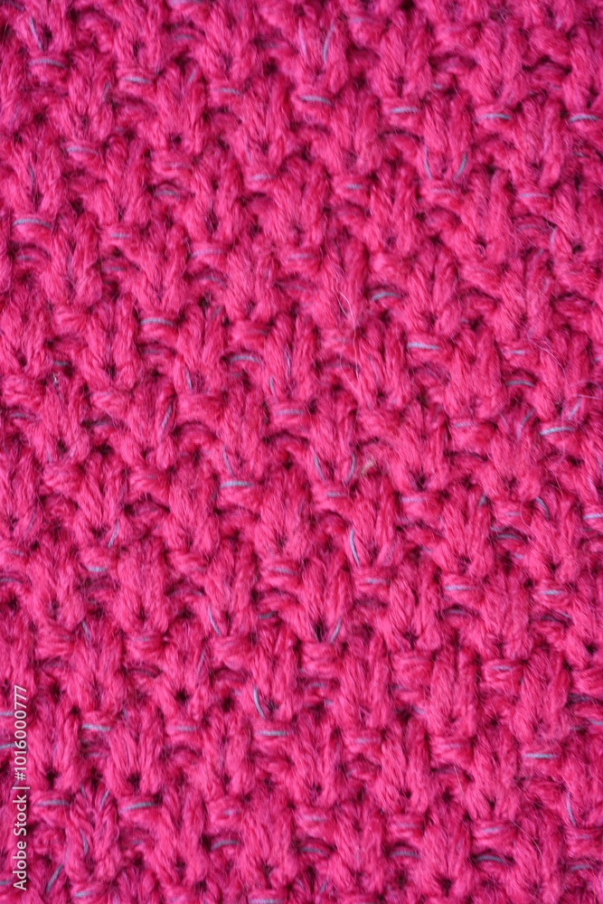 pink texture of knitted wool fabric as a background, smooth symmetrical lines of hand-knitted needlework pattern pink texture of knitted wool fabric as a background, smooth symmetrical lines of hand-knitted needlework pattern