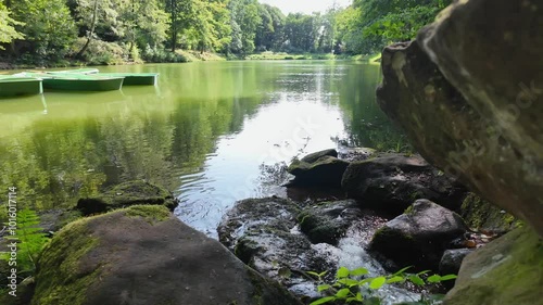 Serene Lake View With Green Rowboats Among Lush Trees in a Peaceful Nature Setting