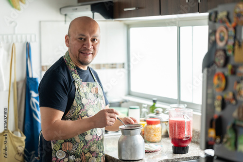Latin man preparing natural juice in the kitchen at home