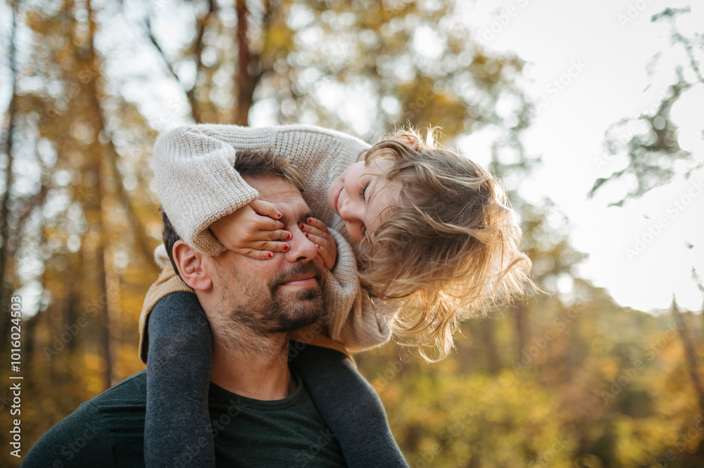 © Halfpoint - Father walking with daughter on his shoulders across autumn forest. Dad and girl having fun outdoors. © Halfpoint - Father walking with daughter on his shoulders across autumn forest. Dad and girl having fun outdoors.