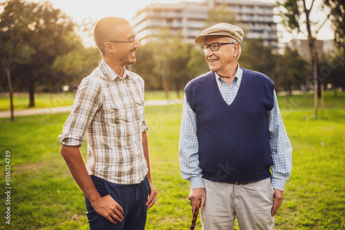 Portrait of happy grandfather and grandson in park.