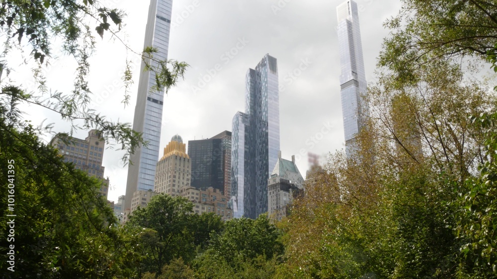 Fototapeta premium New York City Manhattan Midtown. Central park on 5th Fifth 5 avenue, USA. American landmark, urban public park in NYC, United States. Skyscraper buildings architecture, 59 street skyline. Green trees.