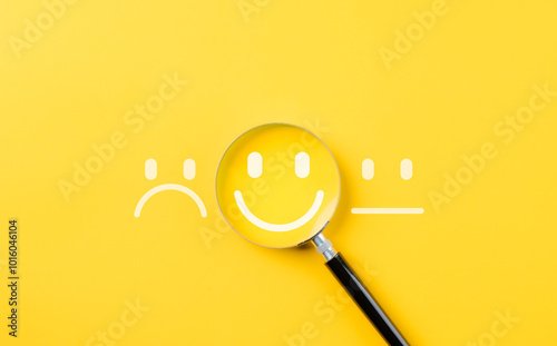 Customer review satisfaction feedback survey concept to gather insights and improve its services. A magnifying glass focuses on smile face among different feedback emoticons on yellow background photo