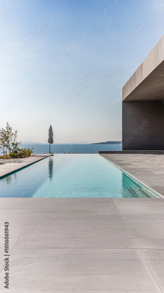 Obraz premium Contemporary pool overlooking serene water and horizon in a modern outdoor setting at sunset