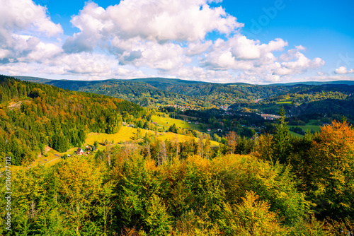 A breathtaking autumn vista unfolds from Spicka lookout tower, showcasing the golden hues of fall foliage and the lush landscape of Tanvald in the Jizera Mountains of Czechia. photo