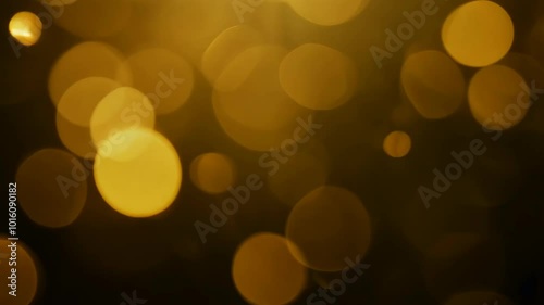 Slow-motion animation of an abstract gold bokeh background with light particles on a dark backdrop, creating a dreamy and defocused photo effect photo