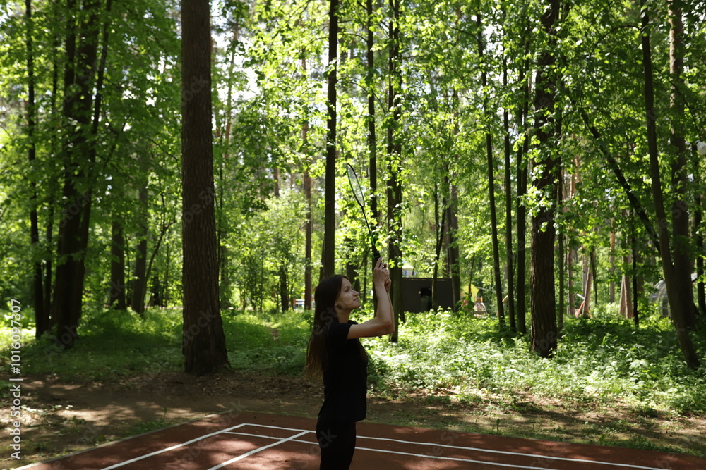 Badminton player, couple enjoying a game in a park, outdoor leisure activity with racket and shuttlecock. Badminton player, couple enjoying a game in a park, outdoor leisure activity with racket and shuttlecock.