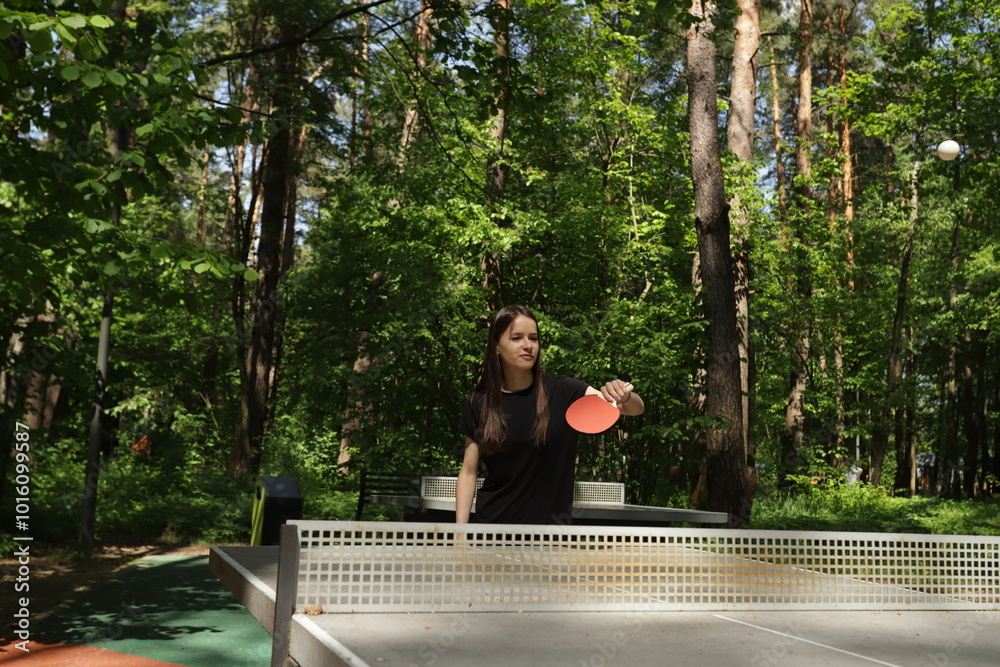 Fototapeta premium Ping pong player, engaged in a table tennis match, playing at a club with other enthusiasts.