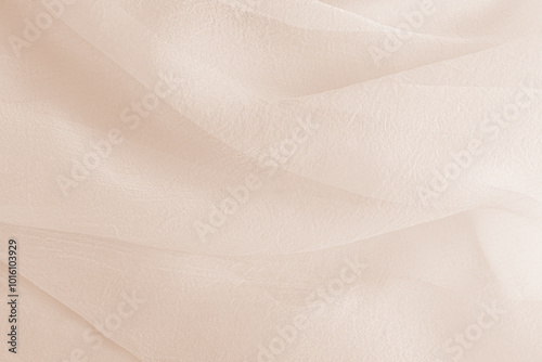 Abstract festive, wedding background with soft waves of chiffon fabric. Delicate pastel beige background. the texture of silk transparent fabric