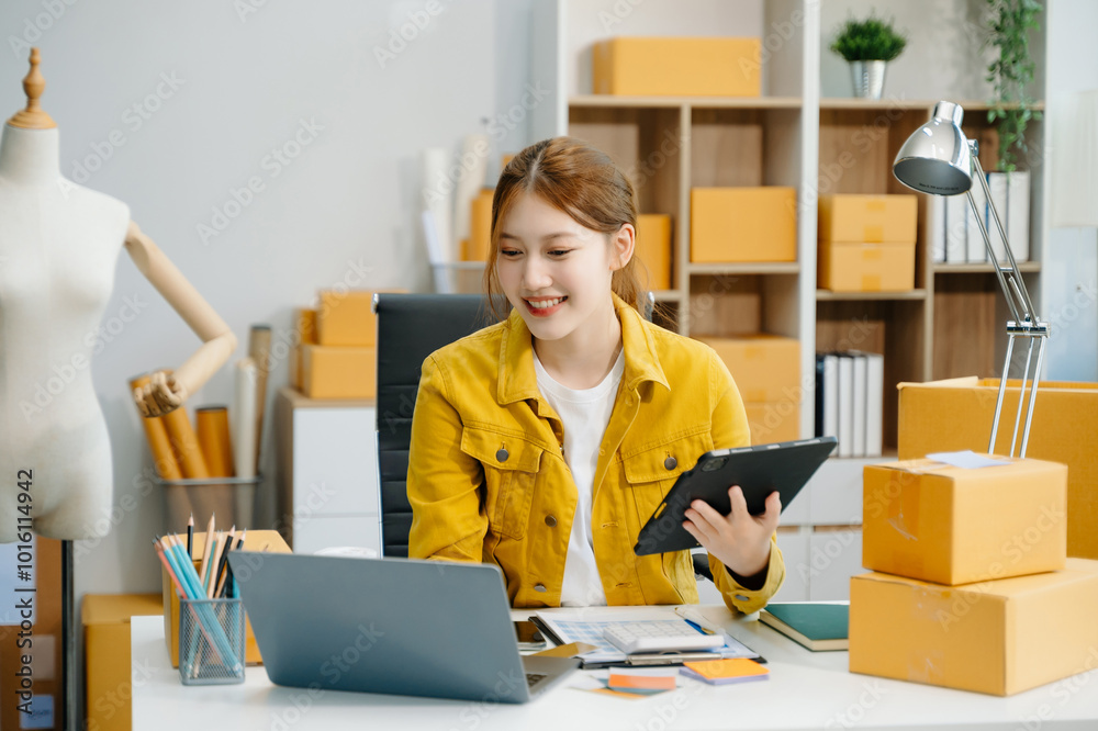 Young woman running online store Startup small business SME, using smartphone or tablet taking receive and checking Young woman running online store Startup small business SME, using smartphone or tablet taking receive and checking