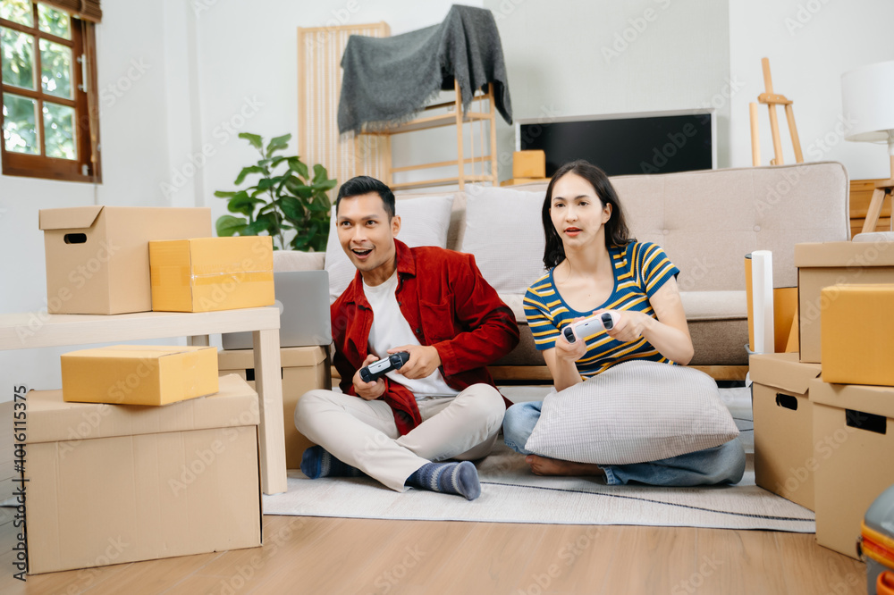 Asia young couple man and woman sit on couch use joystick controller play video game spend fun time together on sofa in living room. Asian married couple Asia young couple man and woman sit on couch use joystick controller play video game spend fun time together on sofa in living room. Asian married couple