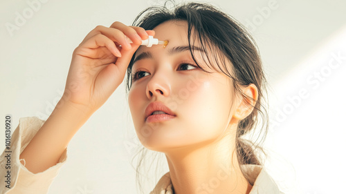 Asian Woman Treating Eye Irritation with Drops