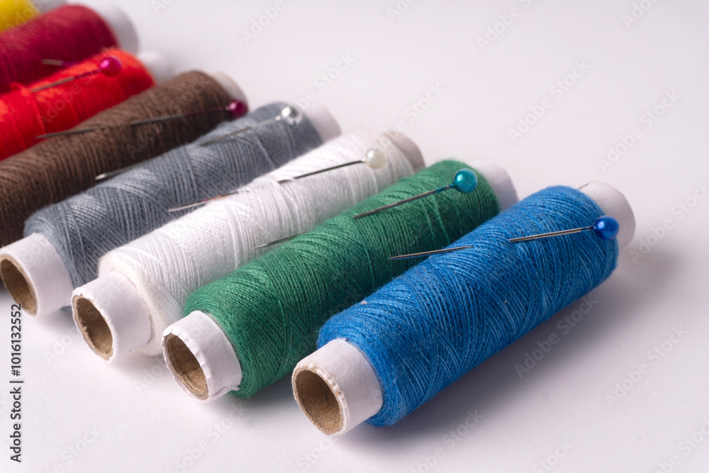 Colorful sewing thread set and needles isolated on background. Colorful sewing thread set and needles isolated on background.