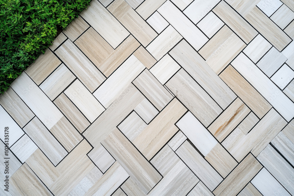 Herringbone patterned tiles with a mix of light beige and white shades, bordered by lush green plants creating a contrast between natural and man-made elements. Herringbone patterned tiles with a mix of light beige and white shades, bordered by lush green plants creating a contrast between natural and man-made elements.