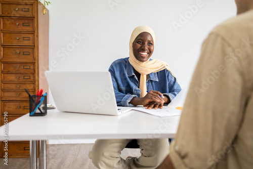 Black female doctor in hijab consulting with a patient photo