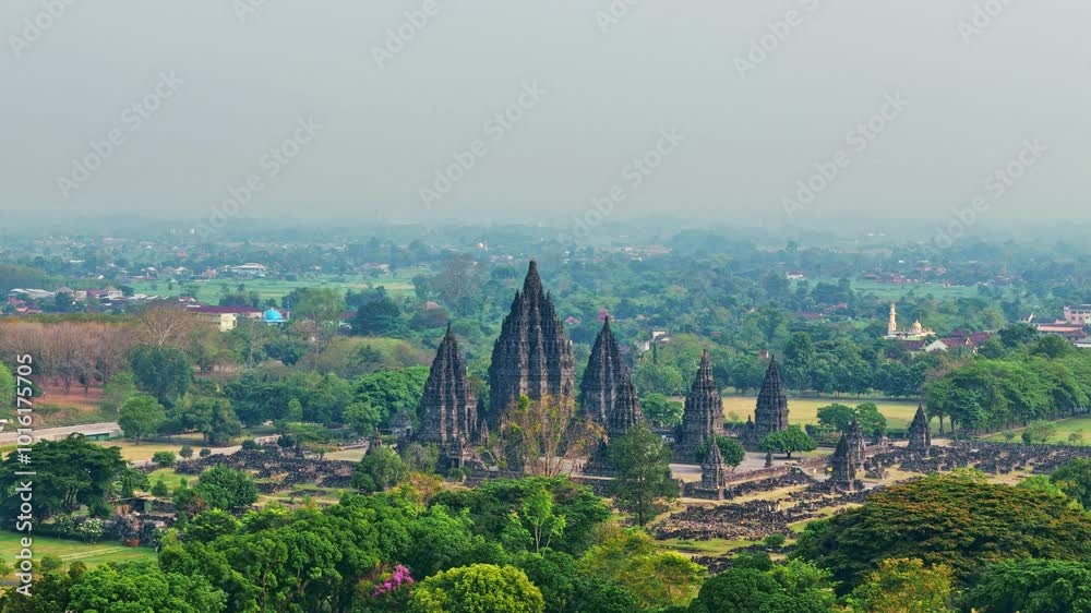 Drone camera flying moving forward to Prambanan Temple from behind the trees. A magnificent Hindu temple with ruins surrounding it, Indonesia. 4K drone footage. Drone camera flying moving forward to Prambanan Temple from behind the trees. A magnificent Hindu temple with ruins surrounding it, Indonesia. 4K drone footage.