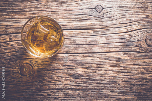 Whiskey glass on an old wooden table. Close up