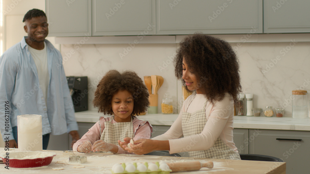 African American happy family at home kitchen mother with daughter cooking baking prepare cook flour dough cookie together lovely father hug child girl and wife hugging cuddling kid and mom culinary African American happy family at home kitchen mother with daughter cooking baking prepare cook flour dough cookie together lovely father hug child girl and wife hugging cuddling kid and mom culinary