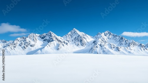 Winter mountain range with dramatic snowy slopes and deep blue sky above untouched snowfields 