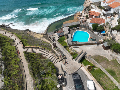 A stunning view of the ocean a pool and a path leading down to a secluded beach photo