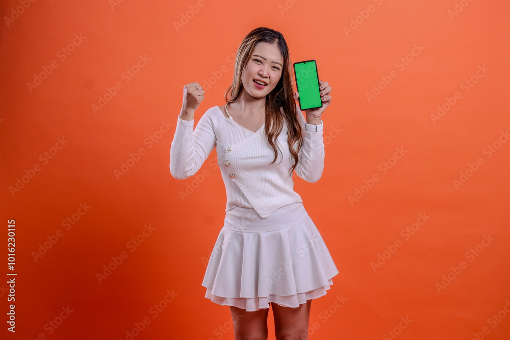 adult ladies in white top standing shouting to camera both hands holding mobile phone screen, cellphone while clenched to the side isolated orange background. for technology, business, promotion adult ladies in white top standing shouting to camera both hands holding mobile phone screen, cellphone while clenched to the side isolated orange background. for technology, business, promotion