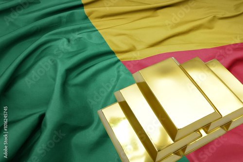 shining golden bullions on the benin flag background. gold reserves.