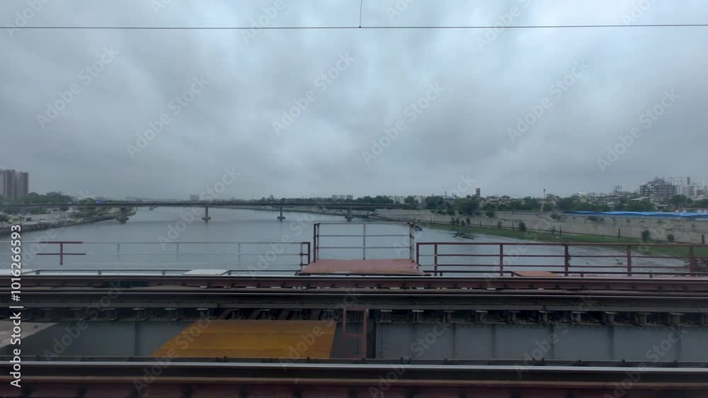 Sabarmati River view from moving train over bridge under cloudy monsoon weather Sabarmati River view from moving train over bridge under cloudy monsoon weather