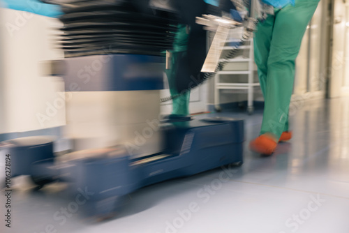 Obraz na plátně Surgeon Walking in Hospital Corridor, the legs of surgeon in green scrubs and co