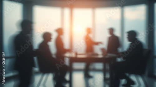 Blurred image of silhouettes of business people, managers, colleagues having a business conversation in a bright office