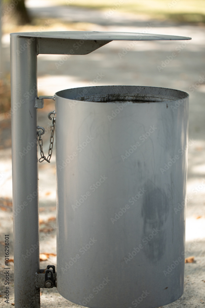 Grey waste bin in the park, modern design Grey waste bin in the park, modern design