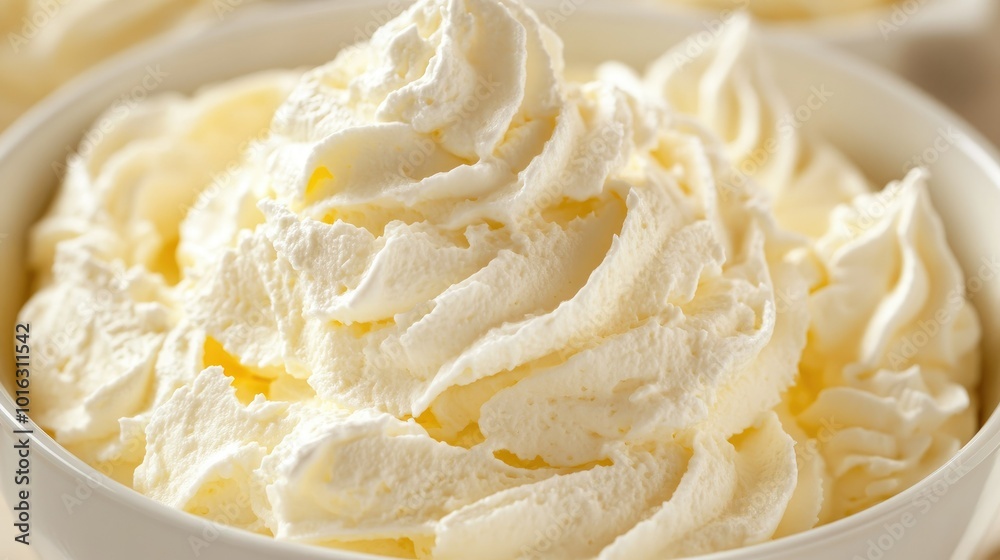 Sweet whipped cream being mixed in a bowl, closeup of texture and smoothness, perfect for cakes. Sweet whipped cream being mixed in a bowl, closeup of texture and smoothness, perfect for cakes.