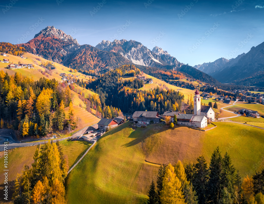 Incredible autumn view from flying drone of Dlijia Da Curt Catholic church, Mareo, Province of Bolzano - South Tyrol, Italy. Colorful morning scene of Dolomite Alps. Traveling concept background.