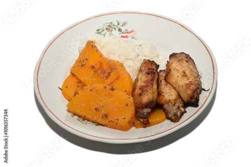 Breakfast on a plate. Rice, stewed pumpkin pieces and grilled chicken wings.