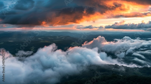 Thick clouds forming over a mountain range during a sunset, creating a dramatic and beautiful scene