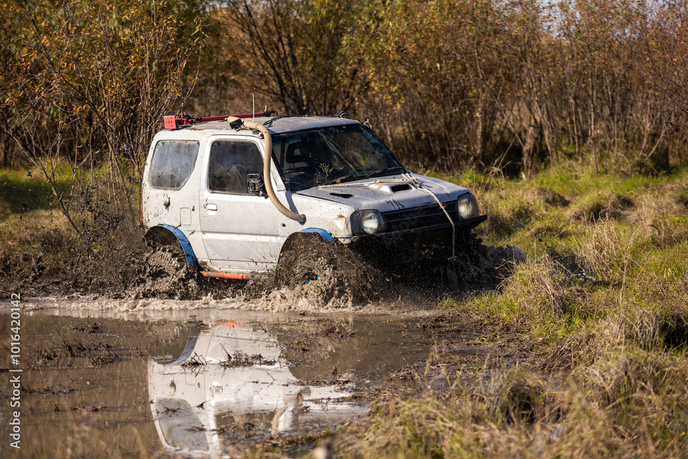 Small japanese suv crossing water obstacle