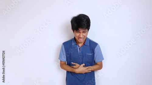 Asian young man sick in stomach area hand gesture holding stomach area isolated photo